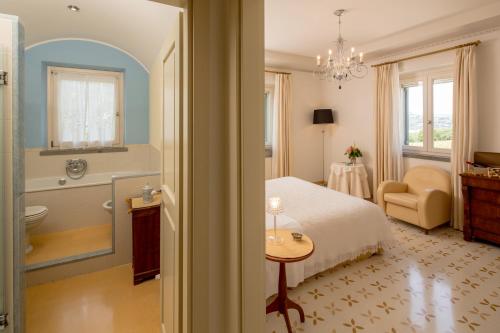 a bedroom with a bed and a bathroom with a tub at Roccafiore Wine Resort & Spa in Todi