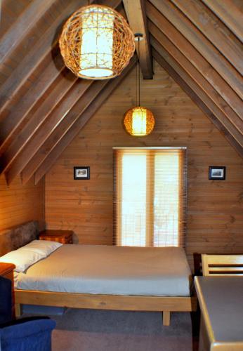 a bedroom with a bed in a room with wooden walls at Loft in Dinner Plain
