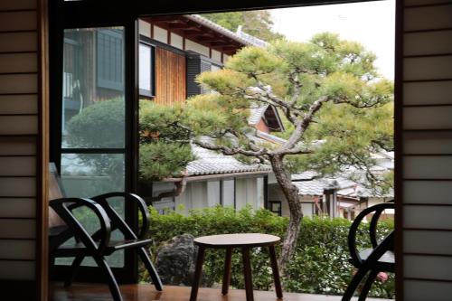 a table and chairs on a porch with a tree at Bob's house in Kameoka