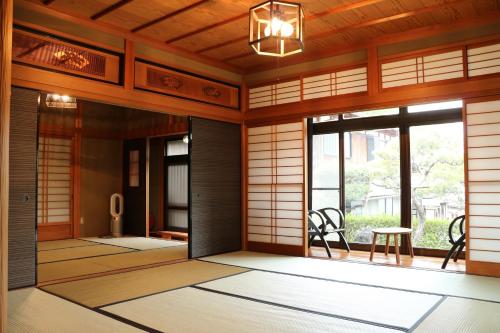 a japanese room with a door and a table and chairs at Bob's house in Kameoka