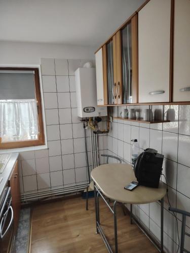 a small kitchen with a table with a bag on it at Apartament in Geoagiu Băi