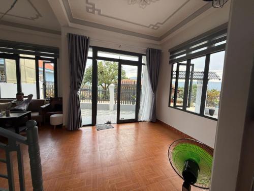 a living room with large windows and a person sitting in a chair at Mây's Villa in Da Lat