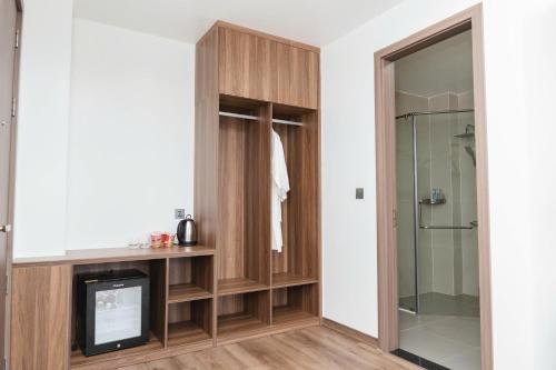 a bathroom with wooden cabinets and a glass shower at Long Hải Hotel in Móng Cái