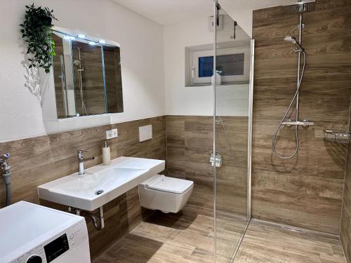 a bathroom with a toilet and a sink and a shower at Appartement Zirbe in Rickenbach