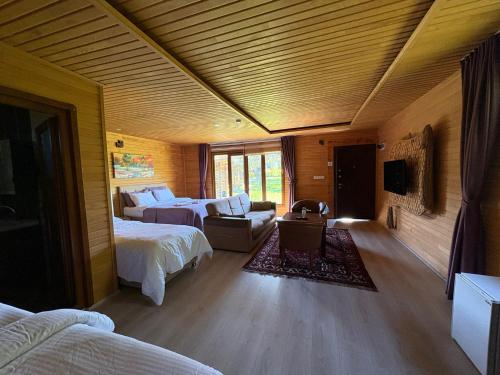 a hotel room with two beds and a couch at pınar kır evi in Artvin