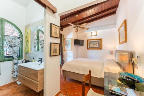 a bedroom with a bed and a bathroom with a sink at Guest House Villa Verde - Short Term Room Rentals in Torre delle Stelle