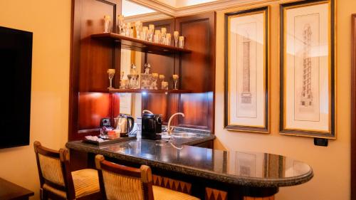 a kitchen with a bar with a sink and chairs at River Chateau Hotel in Rome