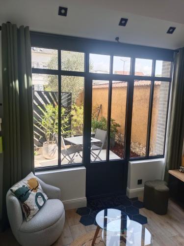 a living room with a window and a chair and a table at L'atelier Maillot in Évreux