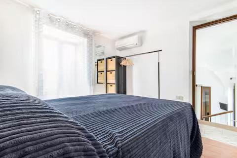 a bedroom with a bed with a blue blanket at Casa Normanna in Palermo