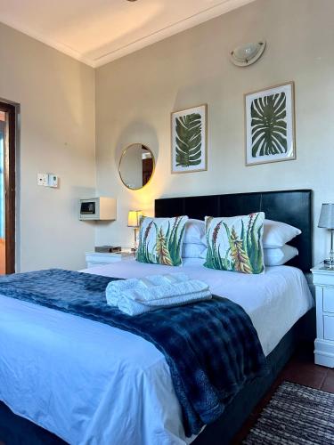 a bedroom with a large bed with a blue blanket at A Sunflower Stop Backpackers in Cape Town