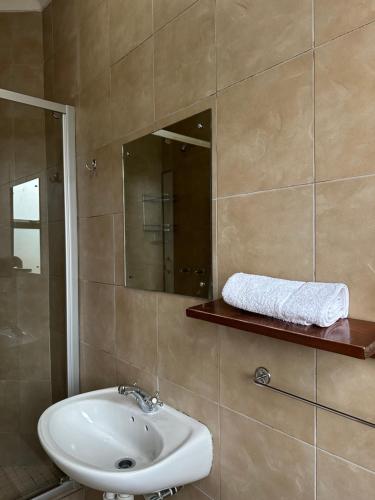 a bathroom with a sink and a mirror at A Sunflower Stop Backpackers in Cape Town