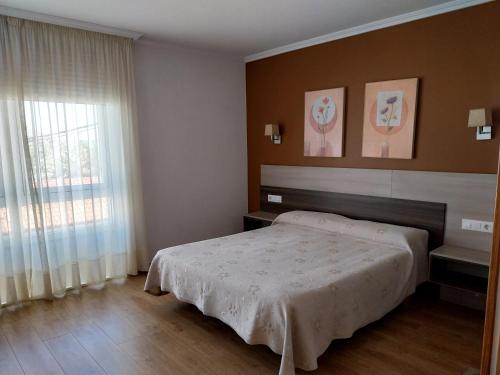 a bedroom with a bed and a window at Pension Begoña in Arzúa