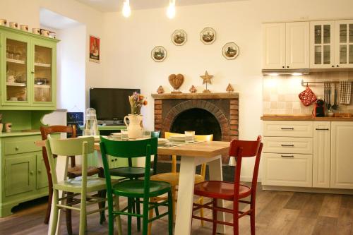 a kitchen with a table and chairs and a fireplace at Locanda dei Gelsomini in Civitella Del Lago