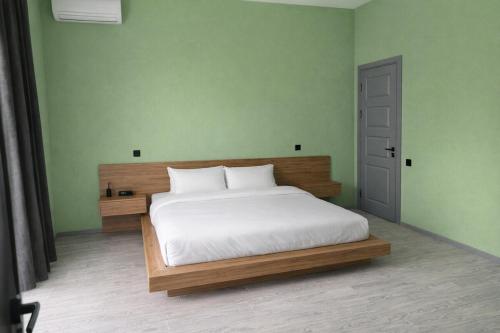 a bedroom with a white bed and green walls at Villa in Mayak in Baku