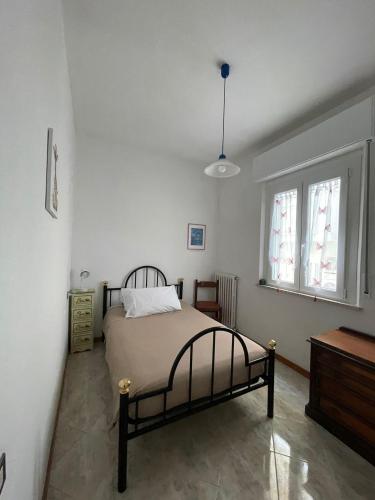 a bedroom with a bed and two windows at Casa Bice in Misano Adriatico