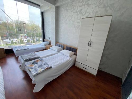 a bedroom with two beds and a large window at Best hotel in Yakkasaray
