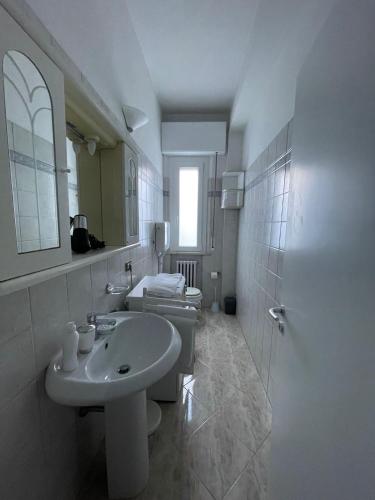 a white bathroom with a sink and a toilet at Casa Bice in Misano Adriatico