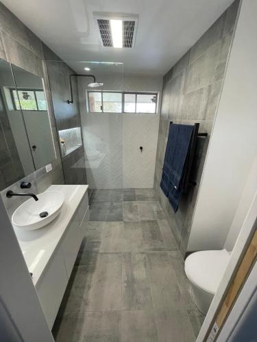 a bathroom with a sink and a toilet at Poolside on the Plateau in Wollongbar