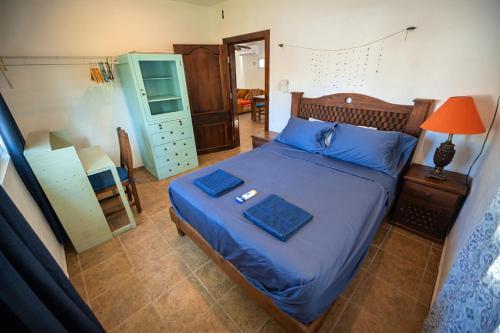ein Schlafzimmer mit einem Bett mit blauer Bettwäsche und einem Spiegel in der Unterkunft Casa Hokol Departamentos con Alberca in Telchac Puerto