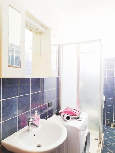 a bathroom with a sink and a washing machine at Levico Centrale Apartment in Levico Terme