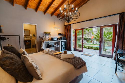 a large bed in a room with a large window at Greenfields Guesthouse & Restaurant in Alberton