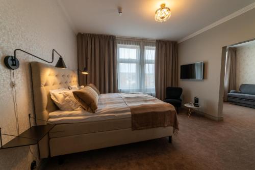 a bedroom with a bed and a tv and a couch at Orsa Järnvägshotell in Orsa