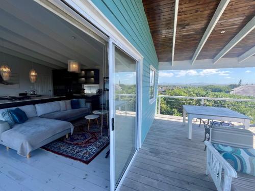 a screened in porch with a couch and a table at The Blue Dragonfly in Jeffreys Bay