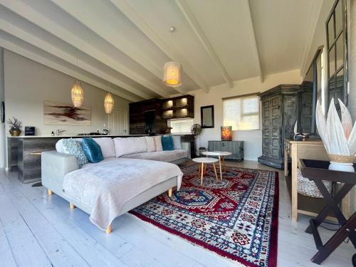 a living room with a couch and a rug at The Blue Dragonfly in Jeffreys Bay
