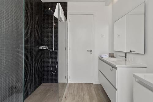 a white bathroom with a shower and a sink at Casa do Azimute by Real Vision in Porto Santo