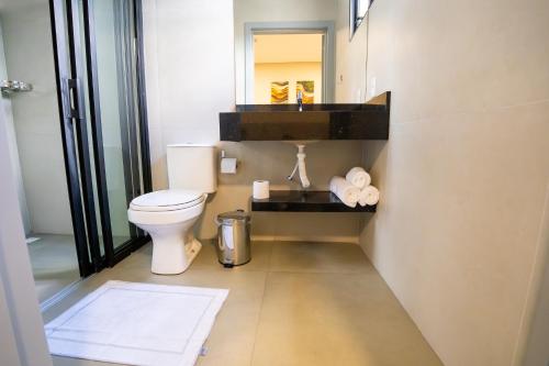 a bathroom with a toilet and a mirror at Barak Hotel in Nova Mutum