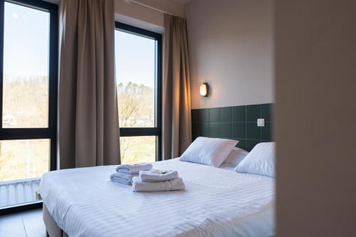 a bedroom with a bed with towels on it at LPM Sporthotel Durbuy in Durbuy