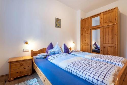 a bedroom with a blue bed and a window at Sallrain Hof Apartment 1 in Collalbo