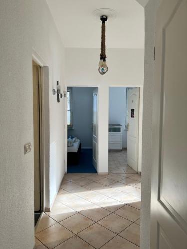 a hallway with white walls and a tile floor at Große Terrassenwohnung mit Seeblick in Stechlin