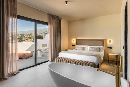 a hotel room with a bed and a bath tub at Hotel Atlantic El Tope in Puerto de la Cruz