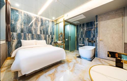 a bedroom with a large bed and a bath tub at 델루나호텔 부평점 in Incheon