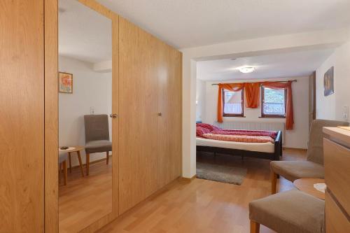 a room with a bedroom with a bed and a table at Haus an der Landhege in Mainhardt