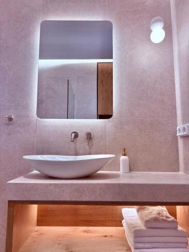 a bathroom with a white sink and a mirror at Enosis Apartments - Kalypso Beach Flat in Agia Anna Naxos