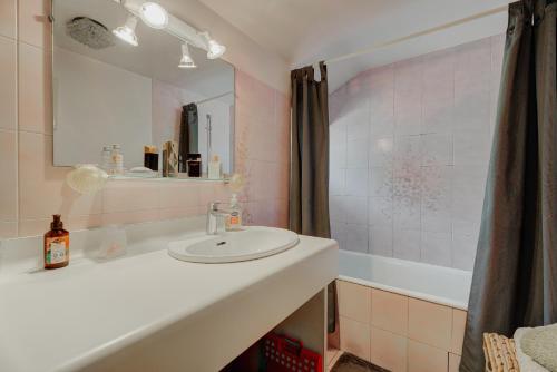 a bathroom with a sink and a mirror and a tub at La maison de la Rebergère in Javené