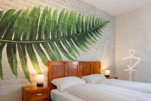 a bedroom with two beds and a mural of a palm tree at Edelweiss Alp Rooms in Castello Tesino