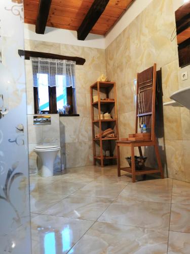 a bathroom with a toilet and a table and a shelf at Greenwood Cottage house for rent near Zagreb in Pisarovina