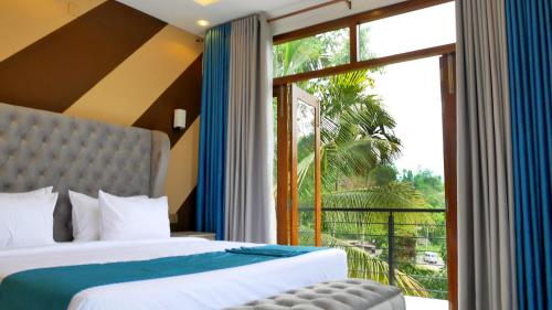 a bedroom with two beds and a large window at Ella, Nine Arch Holiday Resort in Ella