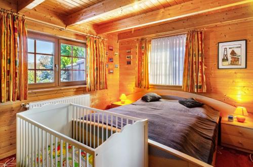 a bedroom with a crib in a log cabin at Emslandstube in Walchum