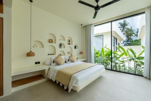 a bedroom with a bed and a large window at Soma House - Adults Only in Kuta Lombok