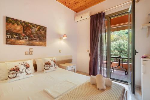 a bedroom with a large white bed and a window at Nontas Homes 34 in Kalamitsi