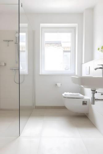 a white bathroom with a toilet and a sink at Steuerbord in Böhl
