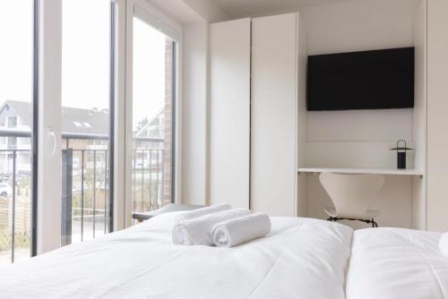 a bedroom with a white bed with towels on it at Steuerbord in Böhl