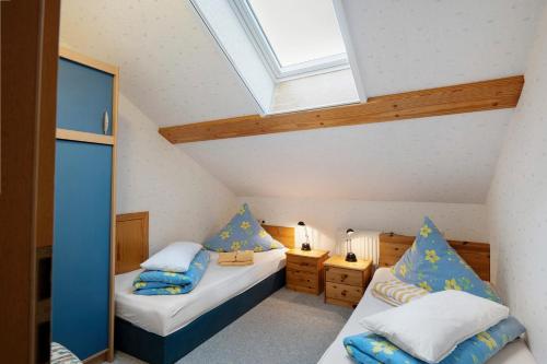 a attic bedroom with two beds and a skylight at Ferienwohnungen Carstensen in Nordstrand