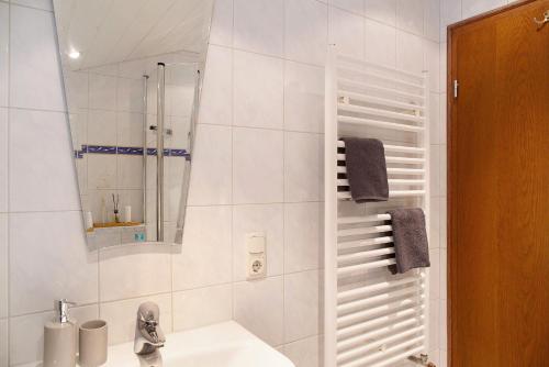 a bathroom with a sink and a shower with a mirror at Ferienwohnung Alpspitznest in Grainau