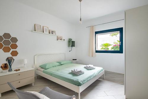 a bedroom with a bed and a desk and a window at Appartamentino in Bari Sardo