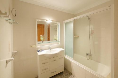 a white bathroom with a sink and a shower at Ca Na Cati in Muro